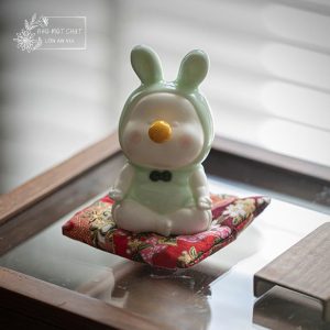 An Mơ – Thỏ gốm men xanh ngọc ngồi đệm vải